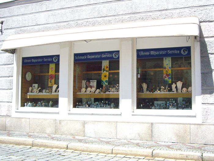 Blick auf das Ladengeschäft von außen mit einem Schild 'Uhren-Reparatur-Service Küspert'